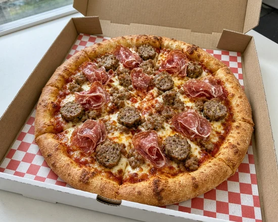 Capone pizza with Italian meatballs, genoa salami, capocollo and Italian sausage in an open pizza box